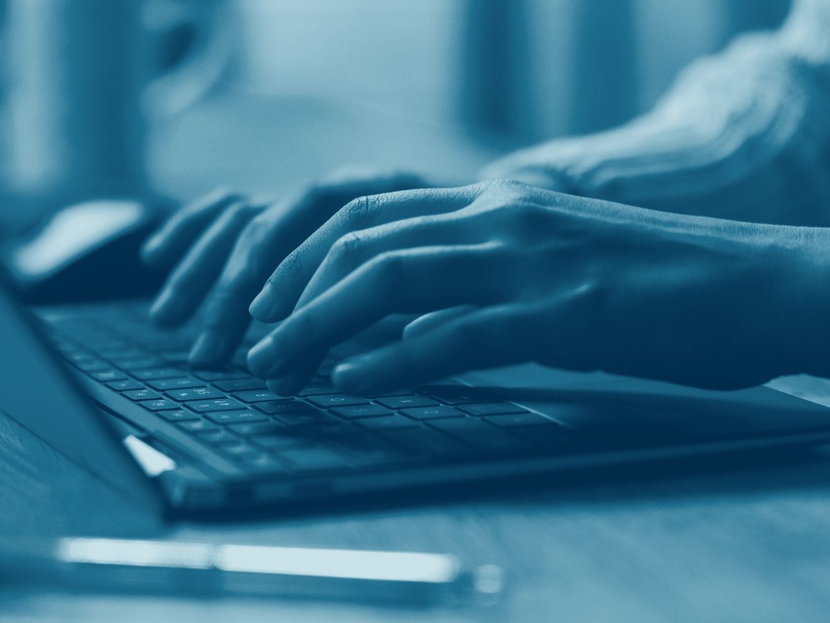 Hands at a laptop keyboard